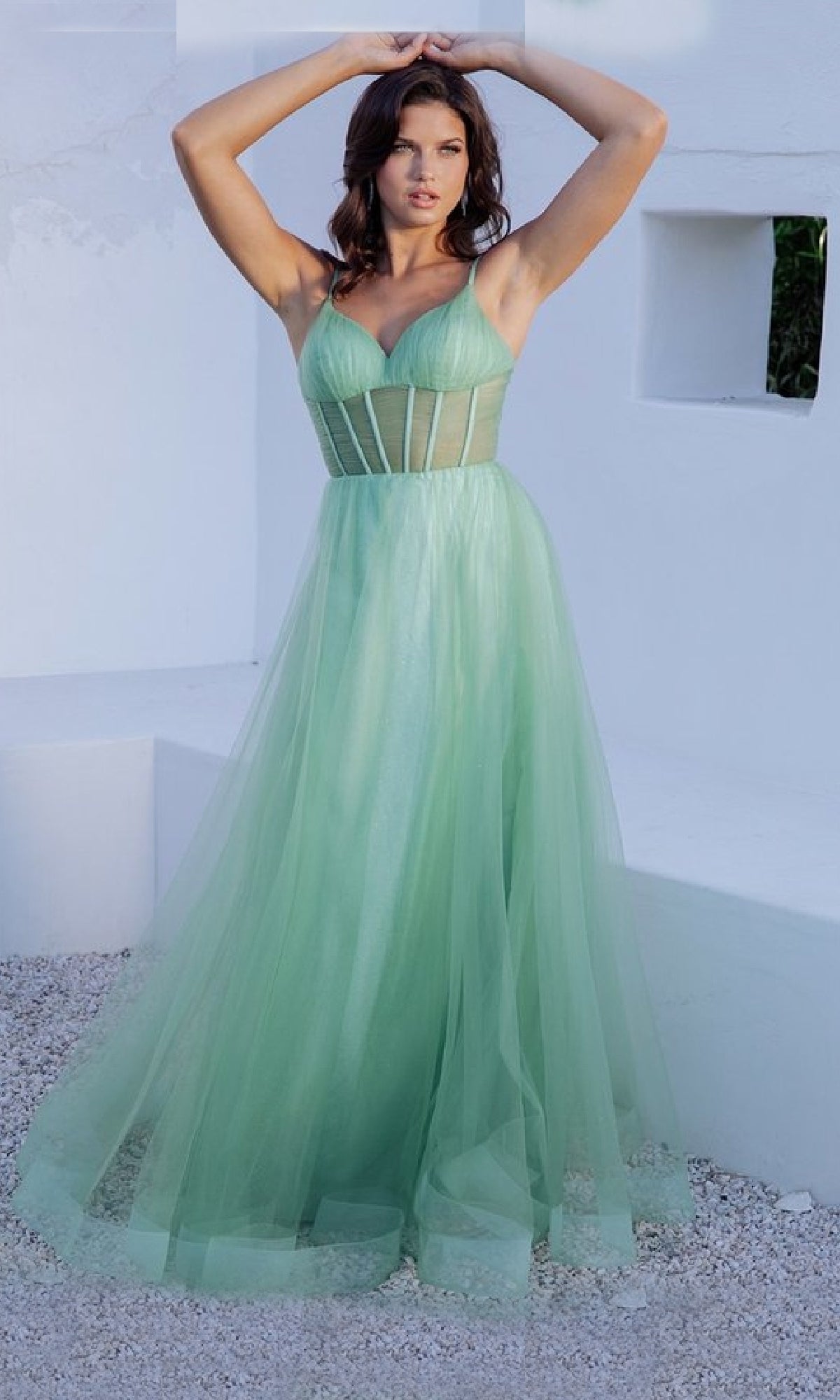 A woman stands outdoors in the Sheer-Corset Long Sage Prom Dress: Eureka 9199, featuring a structured bodice and sheer tulle panels, set against a minimalist white background.